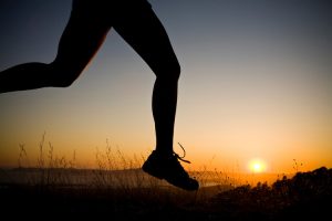 Silhouetted Woman Running on Trail at Sunset